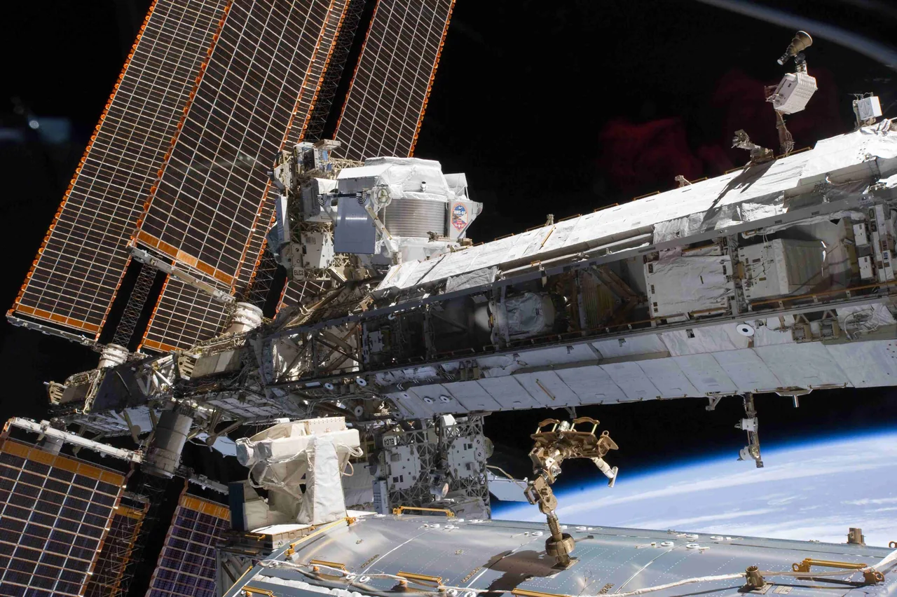 AMS-02 with a visible mission badge stands beside a large solar array on the station truss