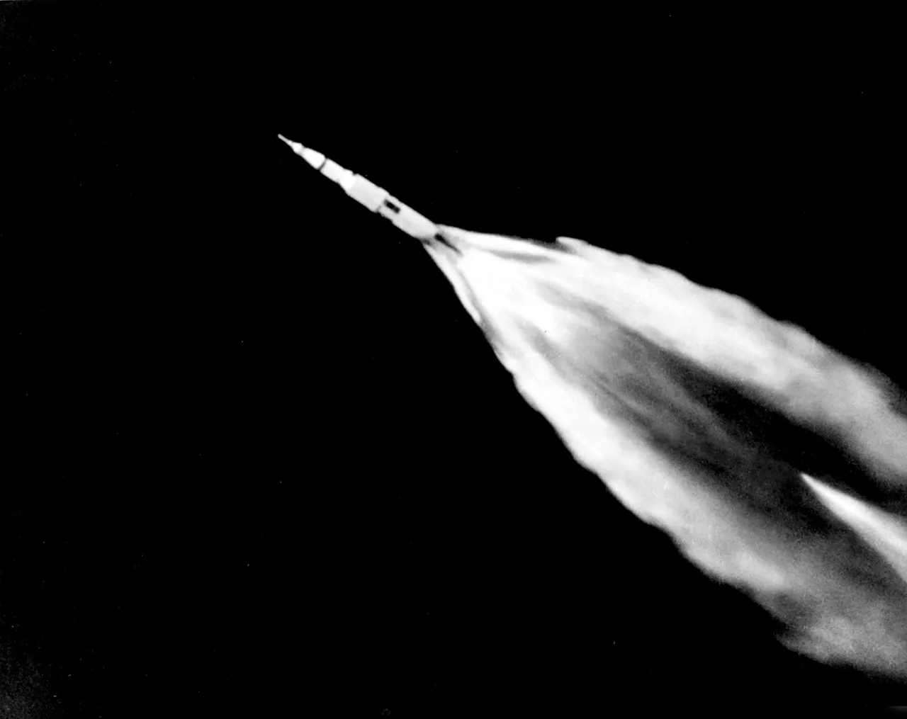 Apollo 11’s Saturn V appears small against the broad, bright trail behind it
