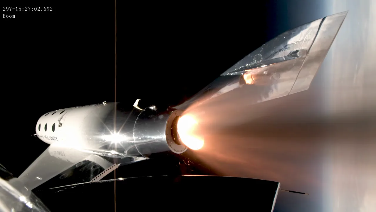 VSS Unity’s fuselage and wing appear beside its bright exhaust plume in a close flight view