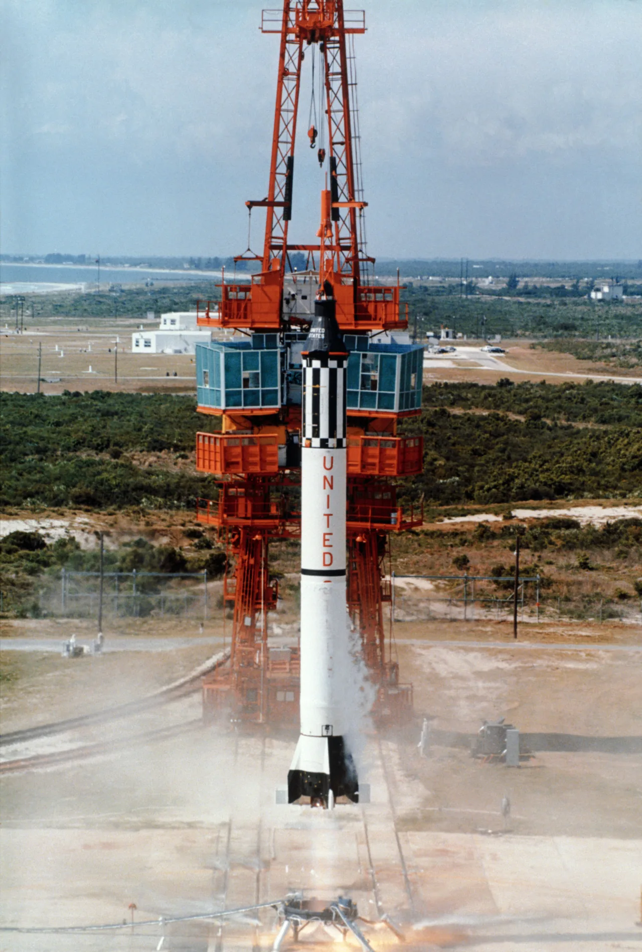 Mercury-Redstone carrying Freedom 7 rising beside its launch structure