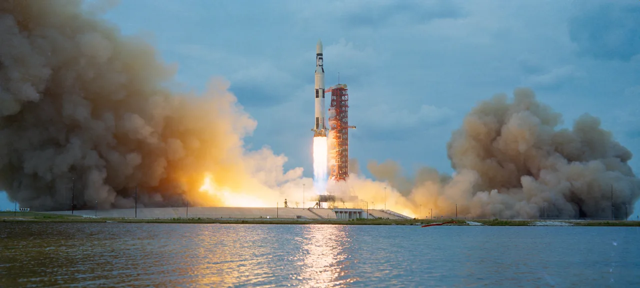 A Saturn V carrying Skylab rises above smoke beside the launch pad