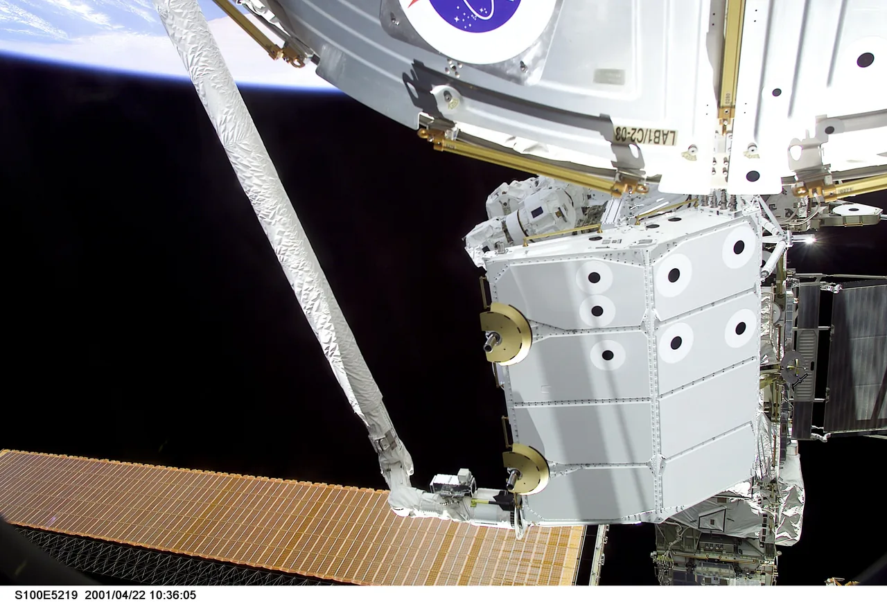 The pallet carrying Canadarm2 is held above Endeavour during installation at the space station