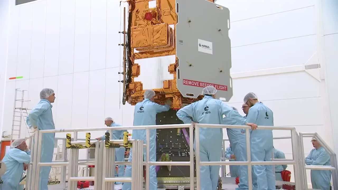 FalconEye 1 suspended above its adapter as clean-room technicians work around it.