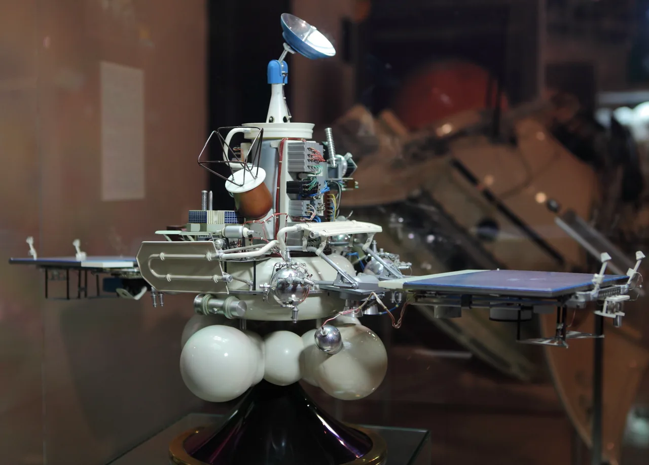 Color museum photograph of a detailed Soviet Fobos spacecraft model with two horizontal blue solar panels, clustered propulsion spheres, exposed instruments, and several antennas.