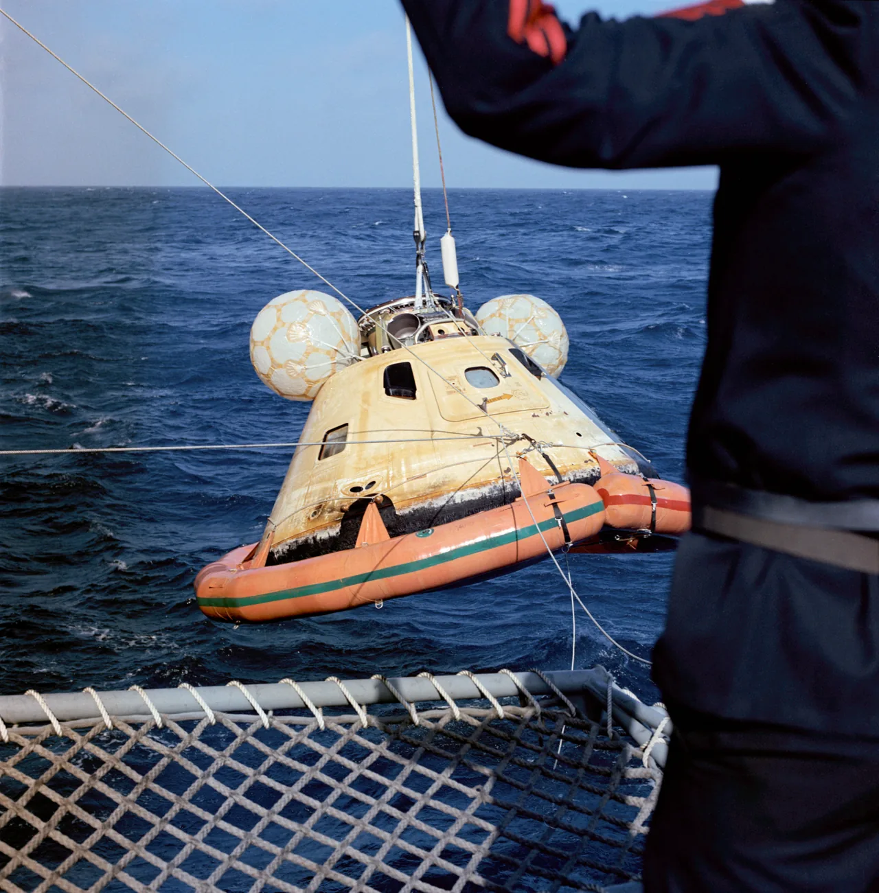 An Apollo command module being recovered from the ocean after Skylab 3