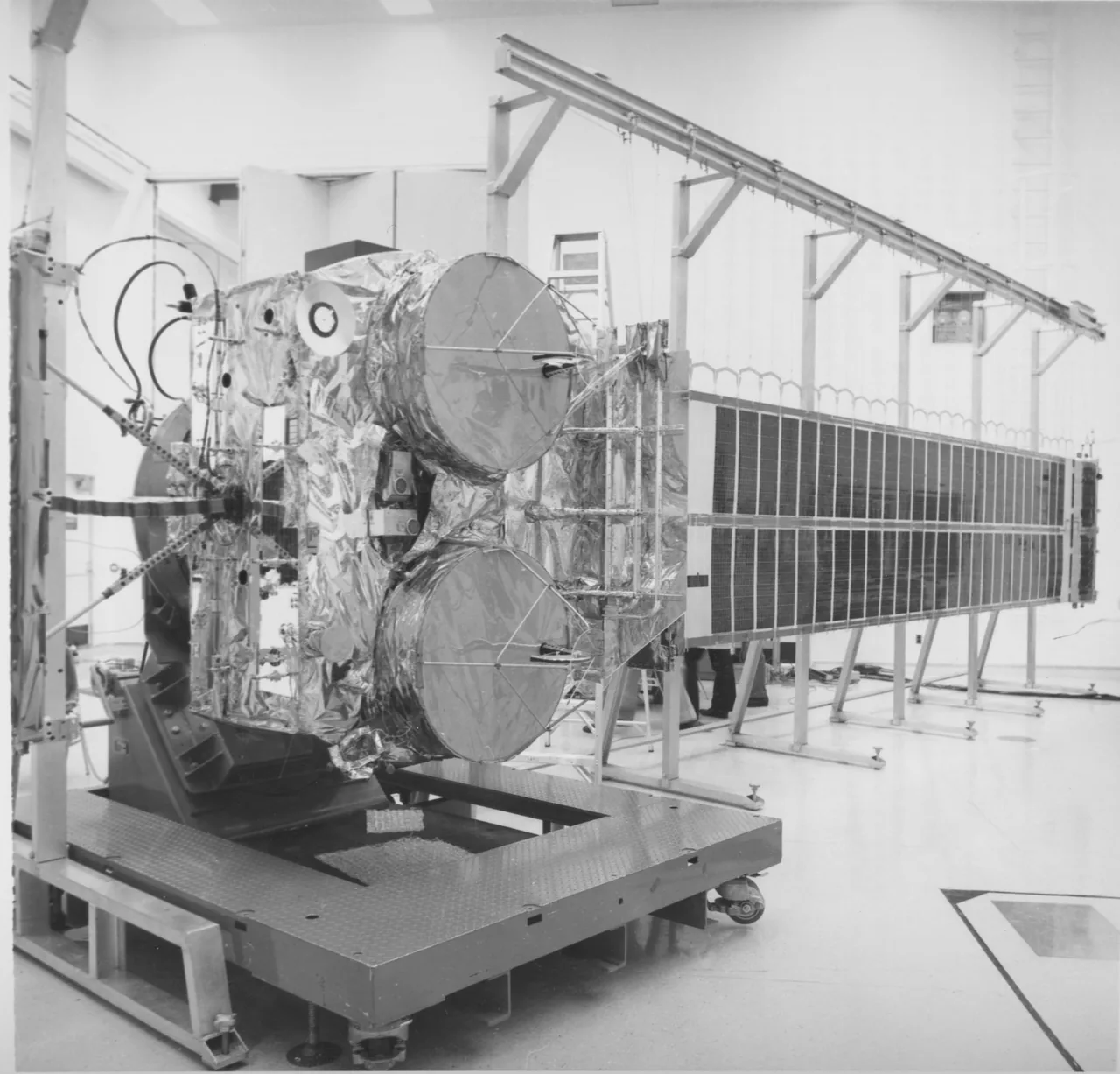 Hermes spacecraft indoors with two circular antennas and an extended solar array supported by ground equipment