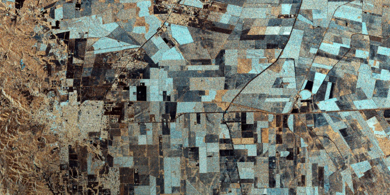 Processed radar image showing angular fields in cyan, brown and dark tones beside textured hills, with bright and dark linear features