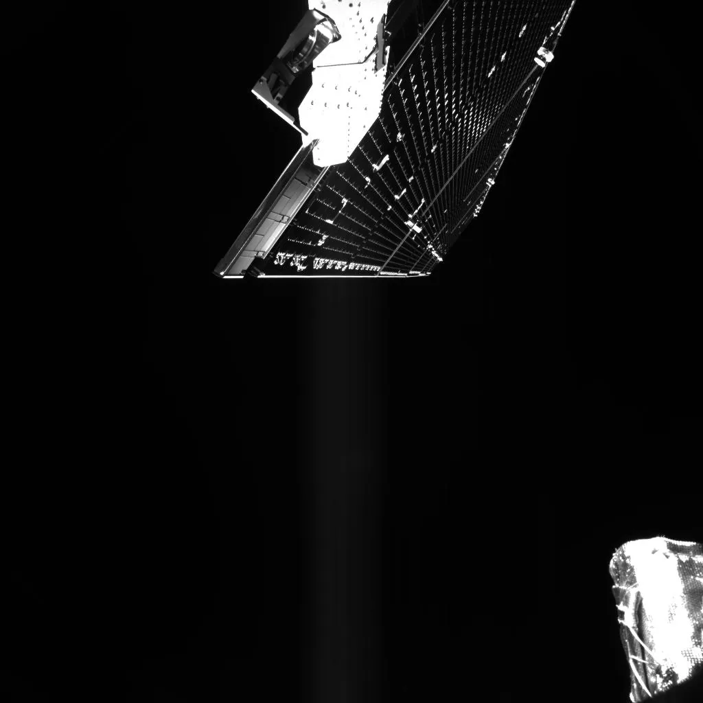 A long BepiColombo solar array extends diagonally into black space, with part of a sun sensor at the lower right.