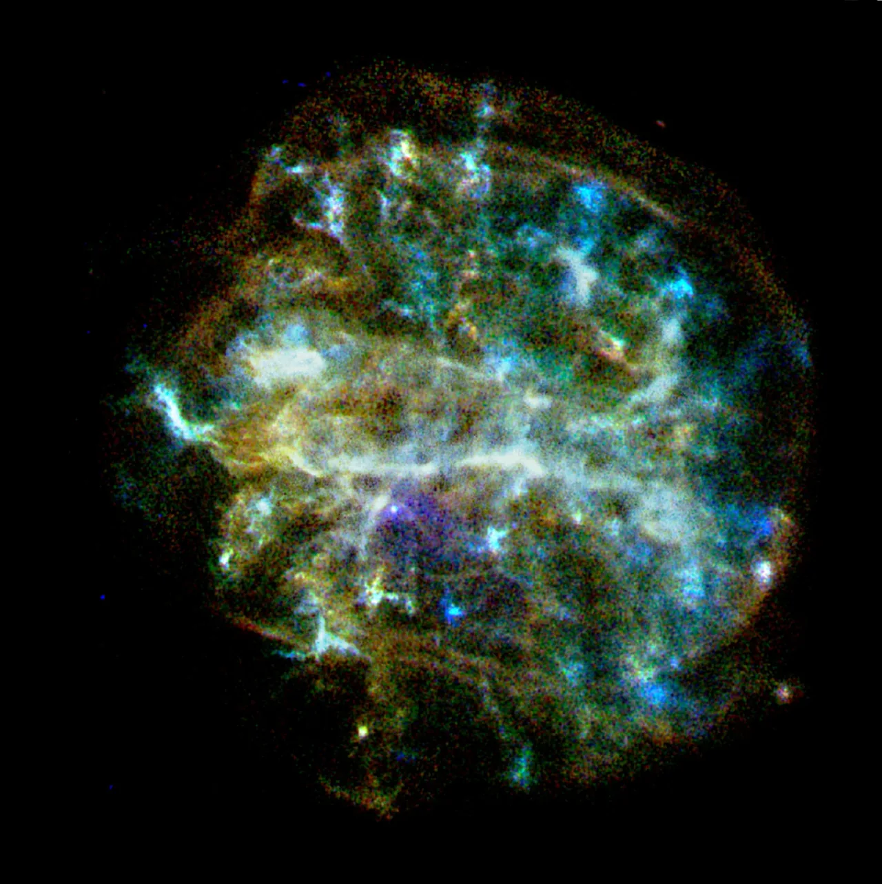 A structured, roughly circular X-ray remnant has bright white and blue knots, fainter green and red edges, and a compact point near a purple central patch.