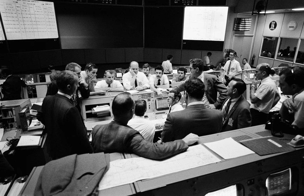 Flight controllers and NASA officials confer at consoles in Mission Control during Apollo 13