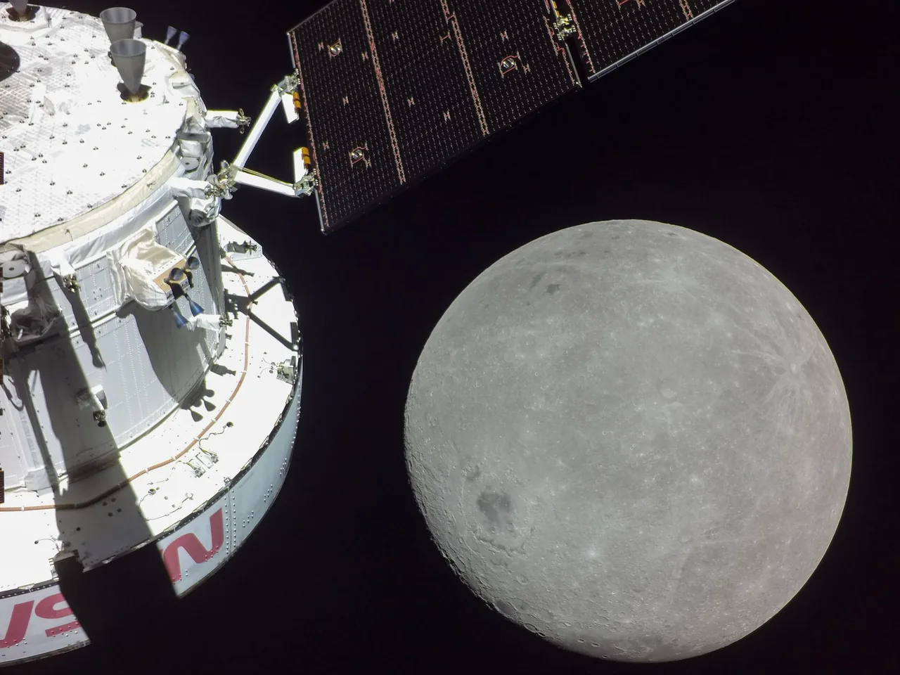 Orion spacecraft hardware and a solar array above the cratered Moon