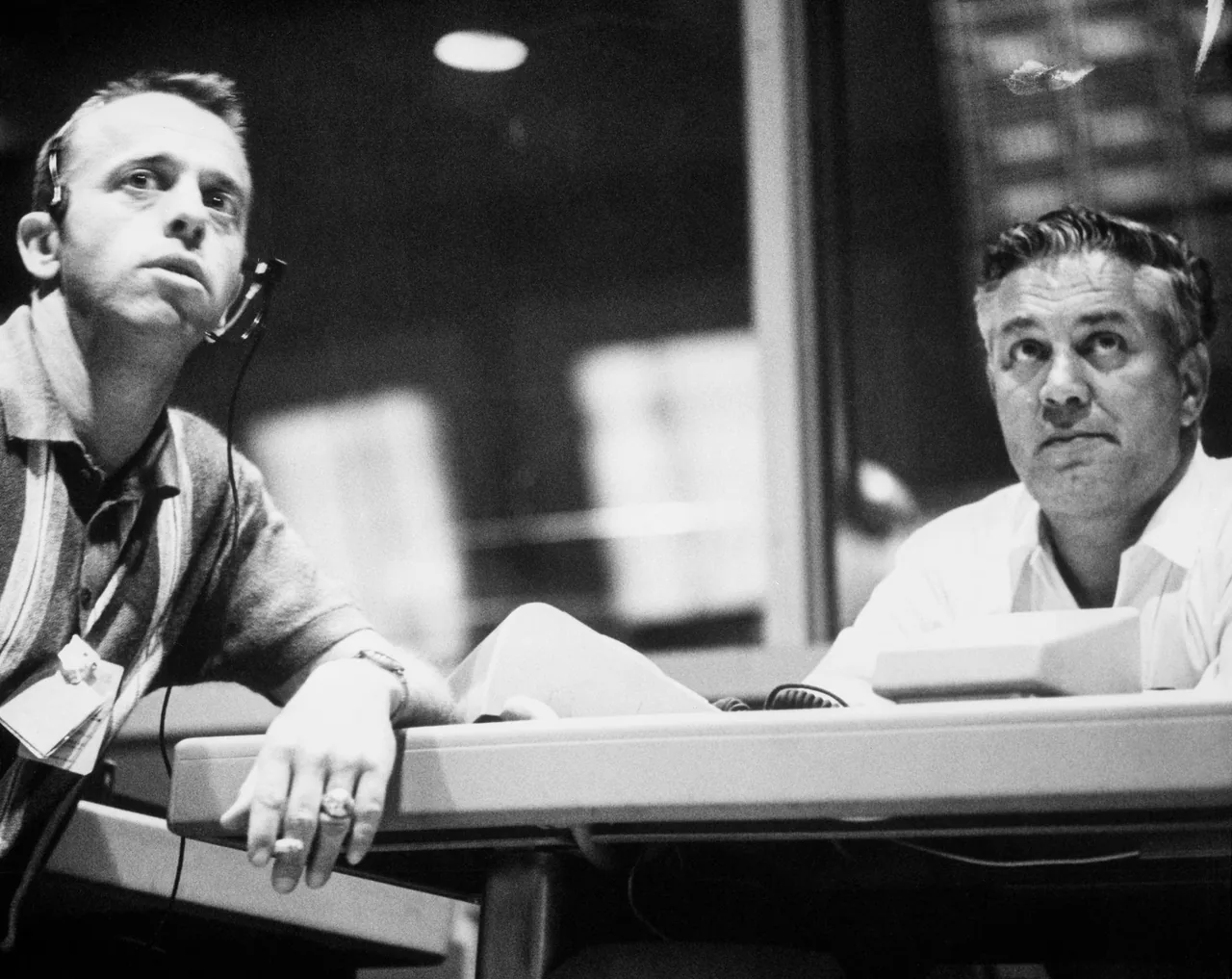 Alan Shepard and Walter Williams wearing headsets and watching Mercury Control Center displays