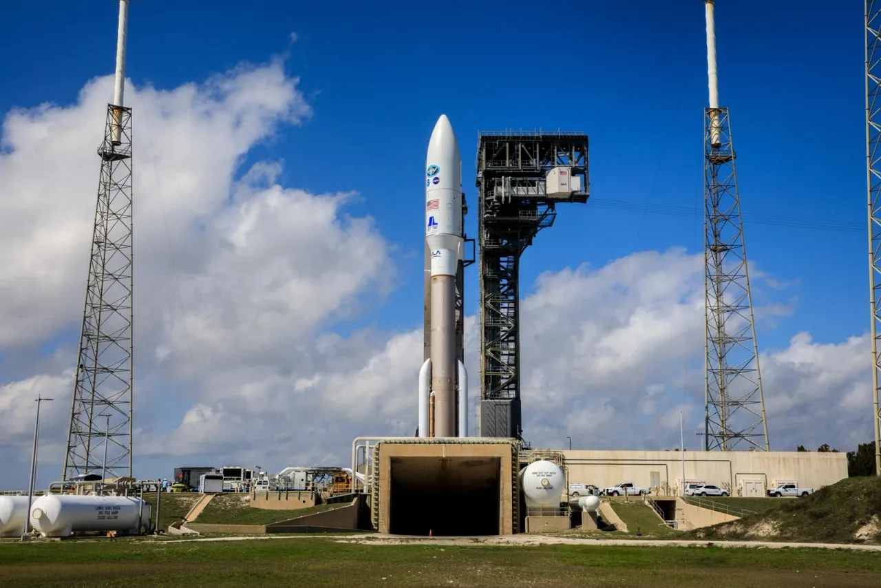 An Atlas V rocket stands at its launch pad beneath a blue sky