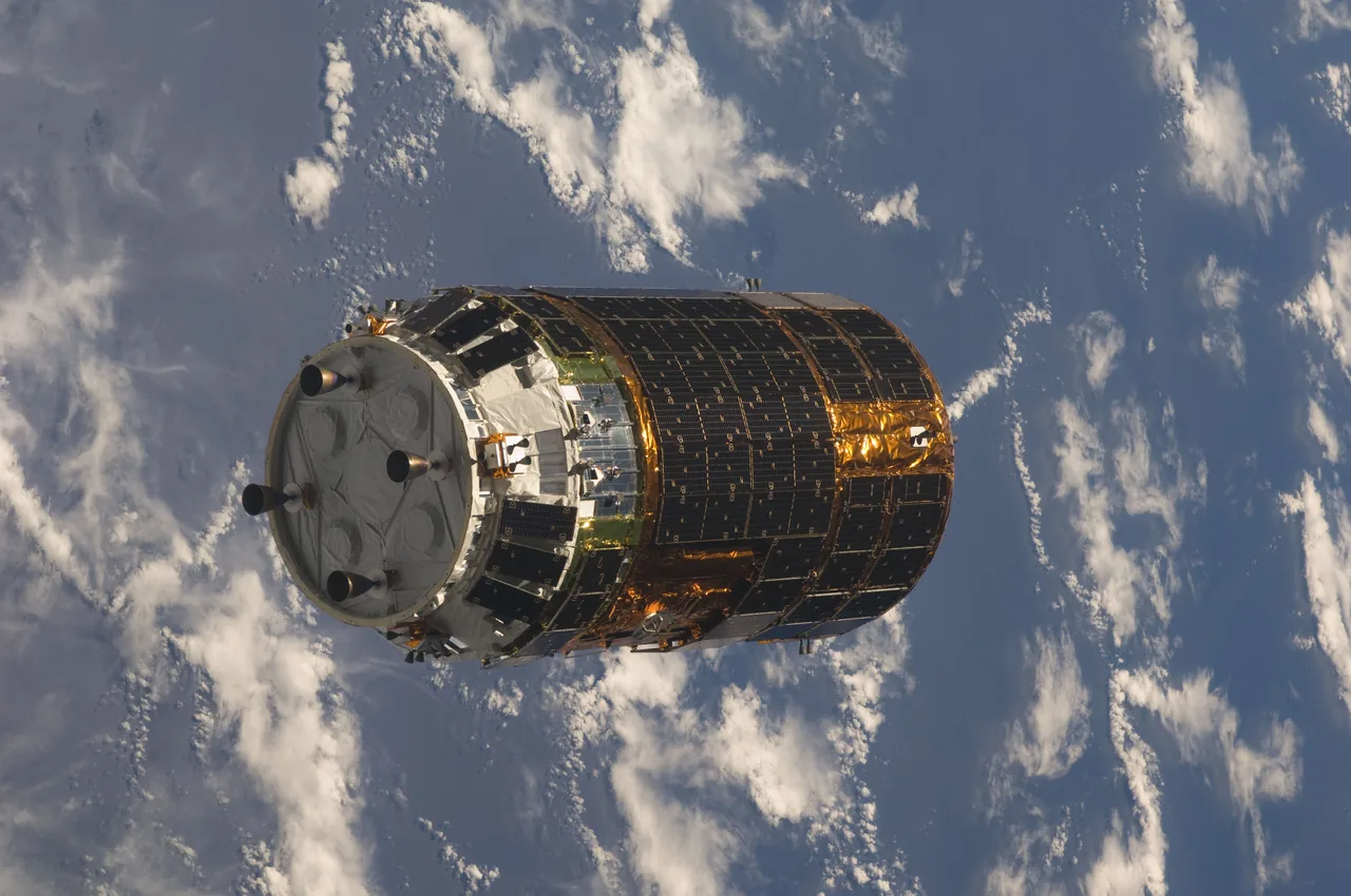 A gold and black cylindrical HTV-1 spacecraft approaches above Earth’s blue ocean and white clouds