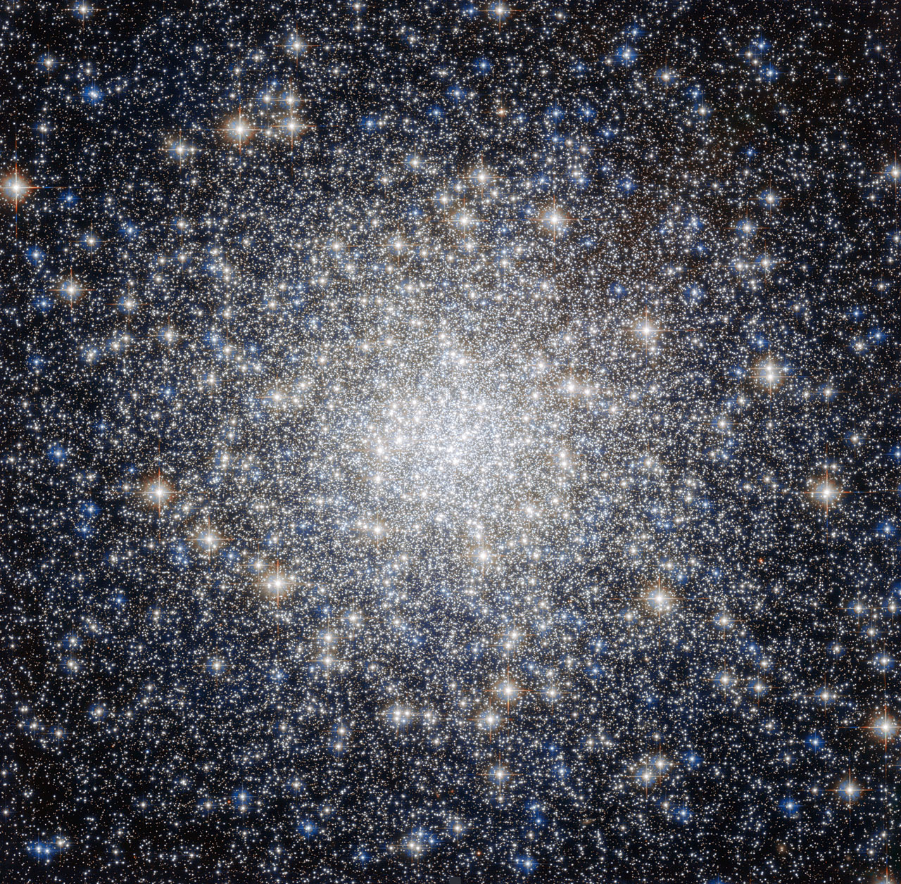 Messier 92 with a dense center of blue-white and orange star points becoming more separated toward the edges.