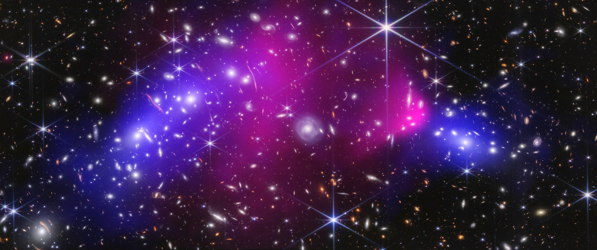 A crowded galaxy field is overlaid with blue lobes of inferred lensing mass on either side and displaced pink X-ray-emitting gas between and above them.