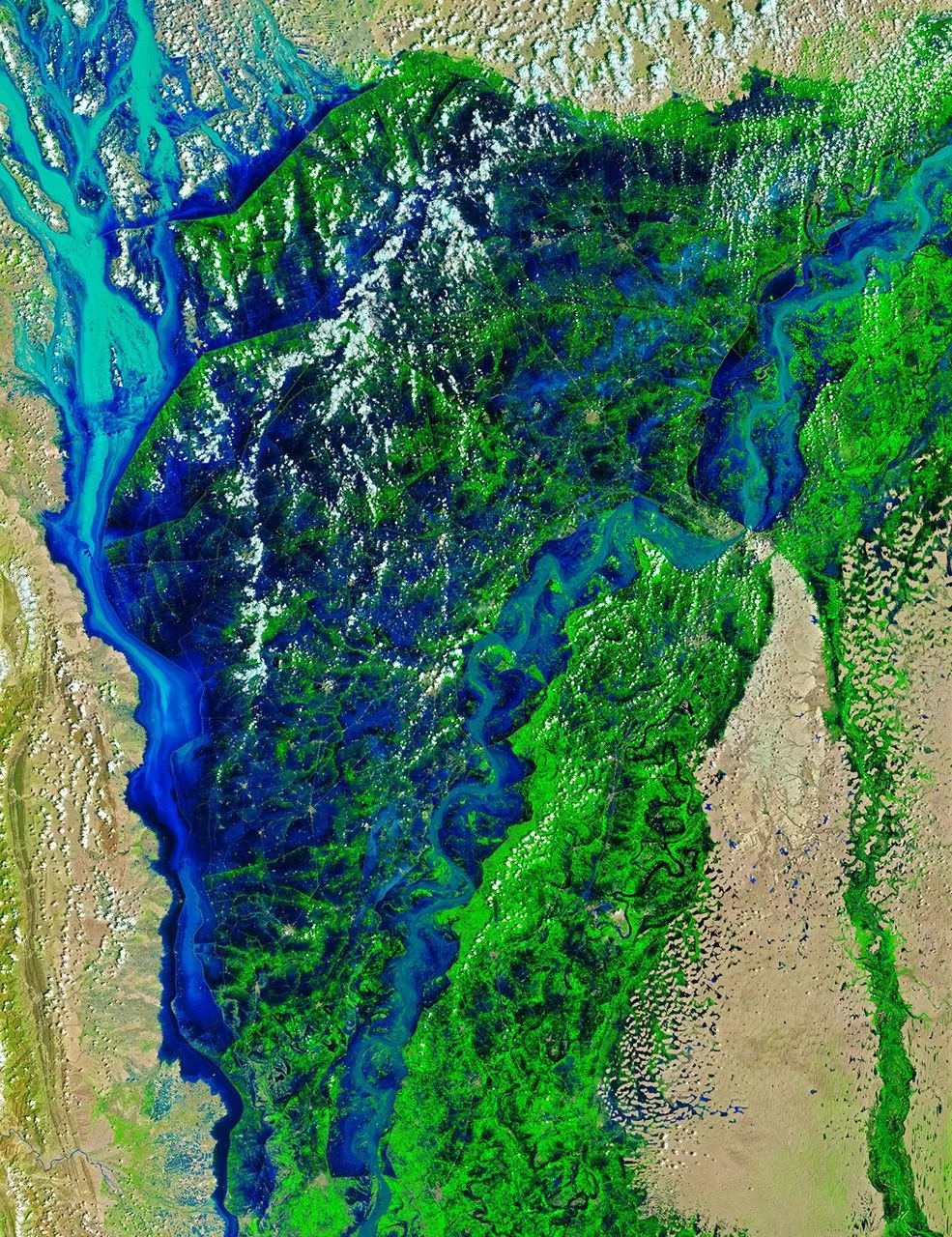 Much broader dark-blue water covers the same green and tan landscape, with scattered clouds
