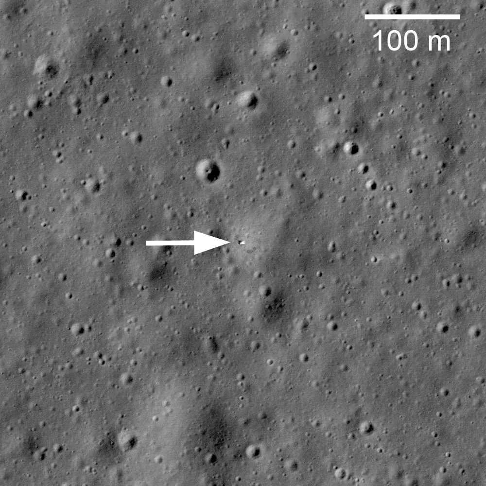 Grayscale orbital view of a cratered lunar plain, with an arrow marking the Luna 17 lander and a 100-meter scale bar at upper right.