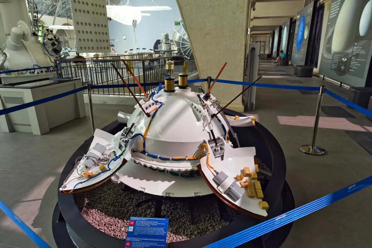 A white Mars 3 lander model with opened petals and antennas on a circular museum stand.