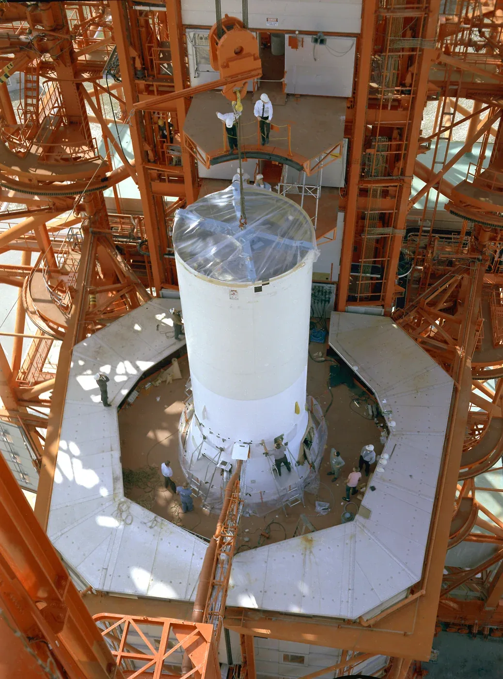 Pegasus 1 hardware is installed above a rocket stage inside a tall service structure