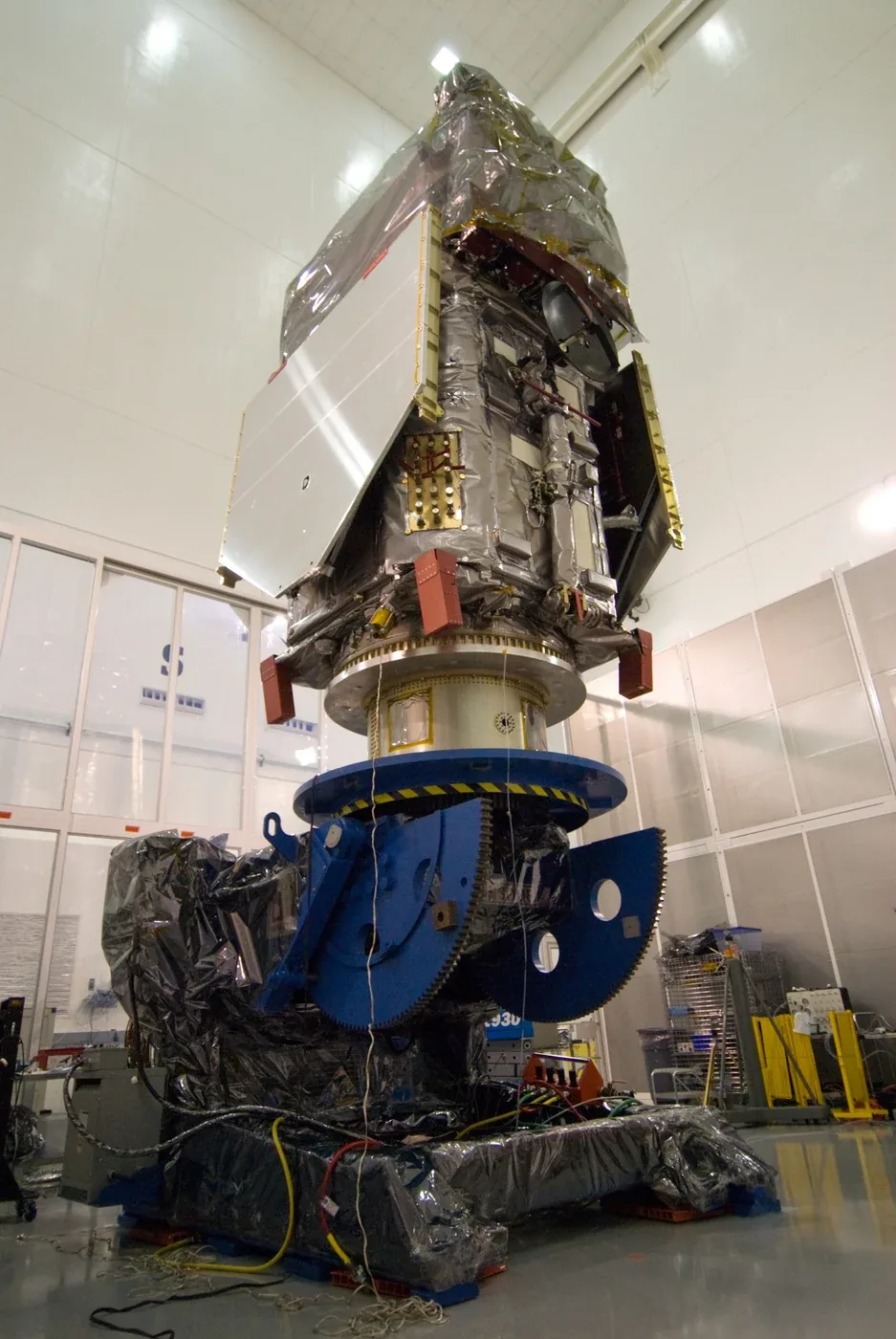 The Solar Dynamics Observatory spacecraft on a blue support fixture inside a clean-room facility