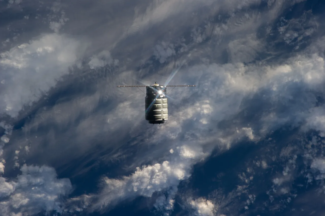 Exact Cygnus Orb-D1 cargo spacecraft approaching the International Space Station with its solar arrays extended above Earth's clouds