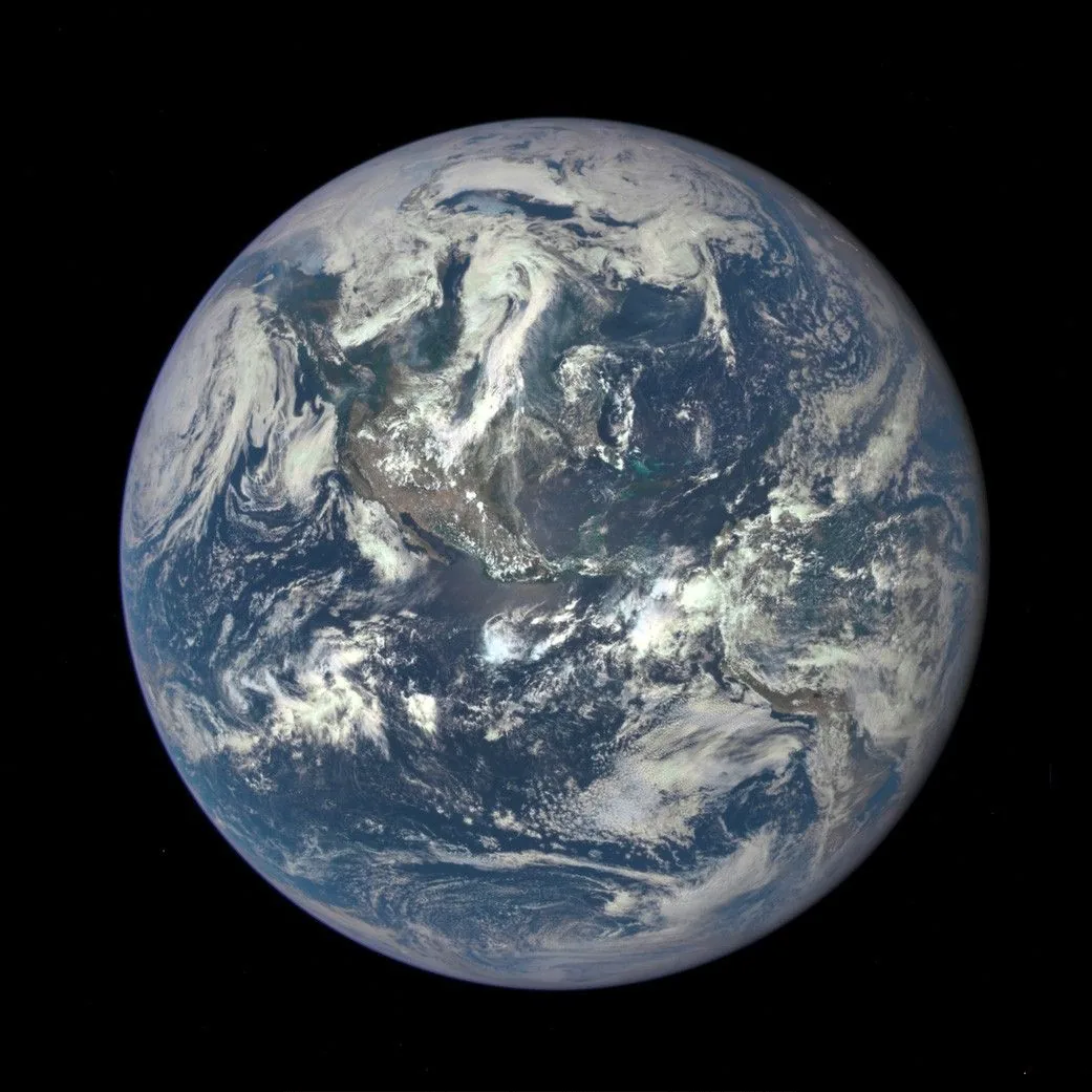 Earth’s sunlit disk with the Americas, blue oceans, and swirling white clouds