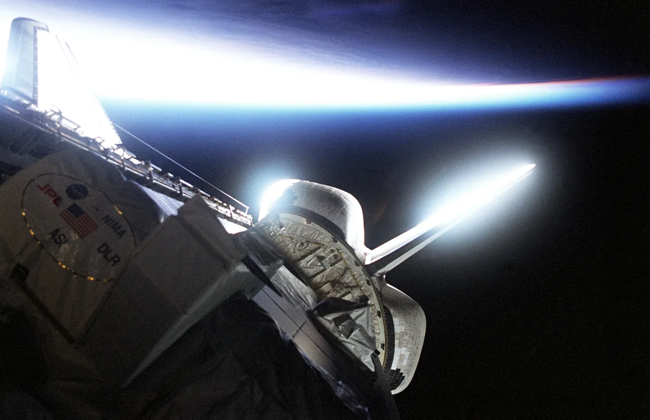 Radar-mapping equipment in Endeavour’s payload bay, silhouetted partly against Earth’s bright horizon