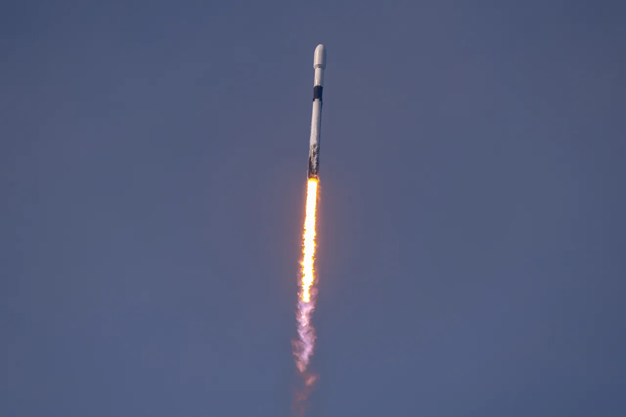 Falcon 9 carrying Nilesat 301 climbs through a blue-gray sky; the spacecraft remains enclosed