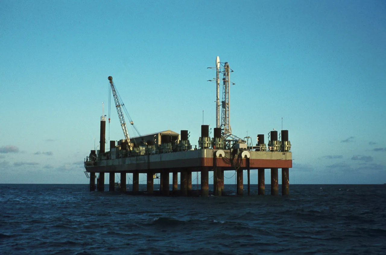 A Scout launch vehicle stands on the offshore San Marco platform surrounded by the sea
