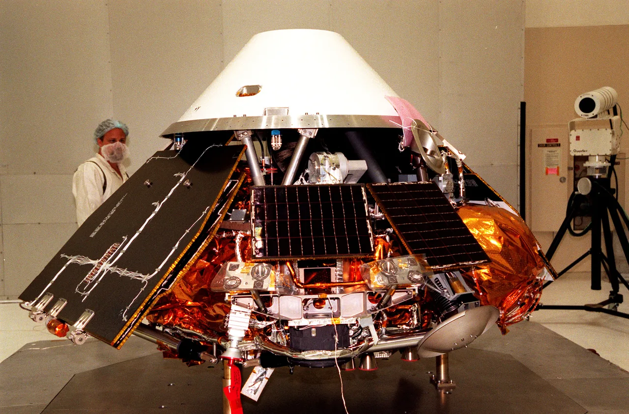 A gold-covered lander with extended solar panels sits beneath a white backshell in a preparation room