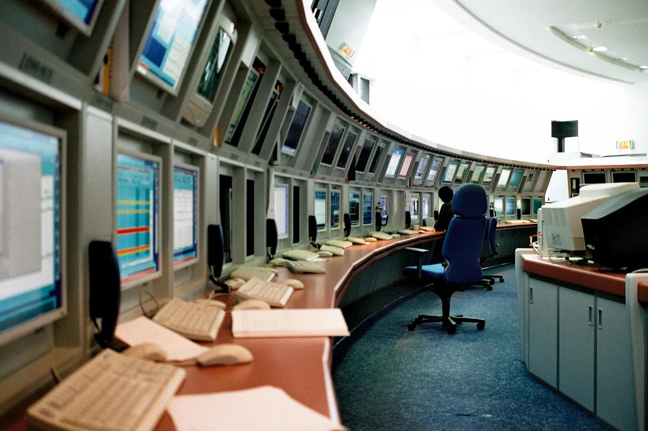 Curved rows of screens, keyboards and chairs in the EUMETSAT control room