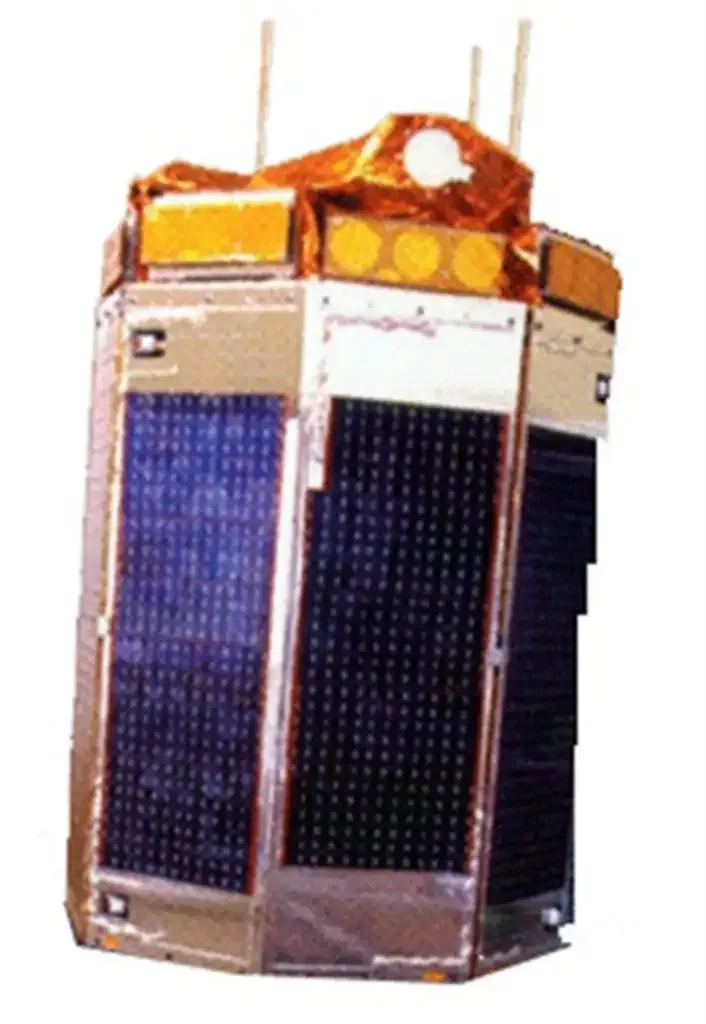 A faceted satellite with dark solar-cell panels, a gold-covered top and projecting antennas is shown against a white background.