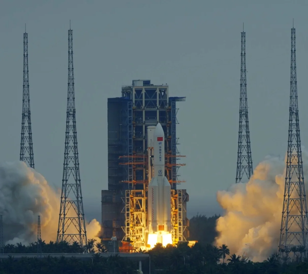 Chang Zheng 5B rocket beginning its ascent from Wenchang amid bright flame and billowing smoke.