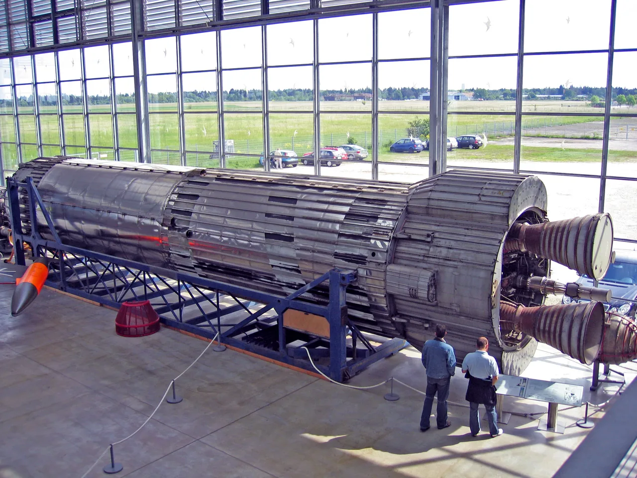 A silver Blue Streak stage lies horizontally in a museum with two engine nozzles exposed