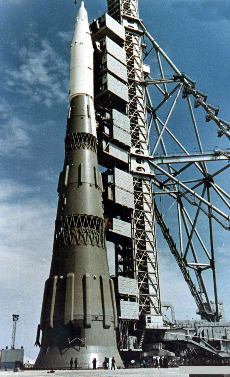 A tall N1 full-scale mockup stands beside a metal service tower under a blue sky