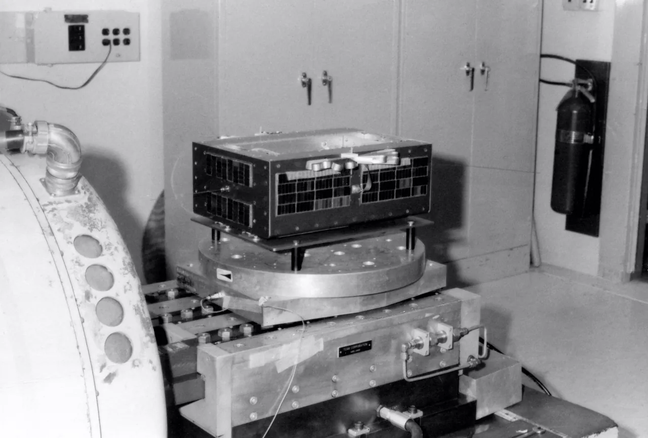 A black-and-white photograph shows AMSAT-OSCAR-6 mounted on a vibration table with folded antenna hardware