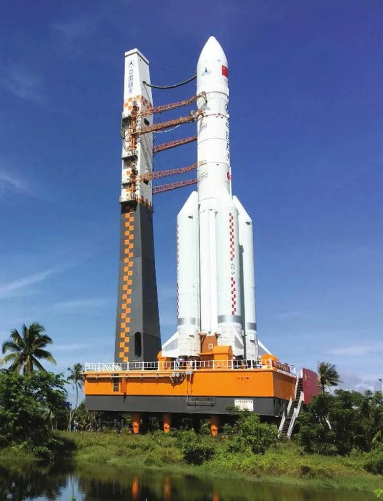 The inaugural white Long March 5 rocket, with side boosters and a pointed fairing, on an orange mobile platform at Wenchang.