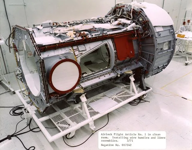 Skylab’s cylindrical Airlock Module with internal equipment visible during ground work
